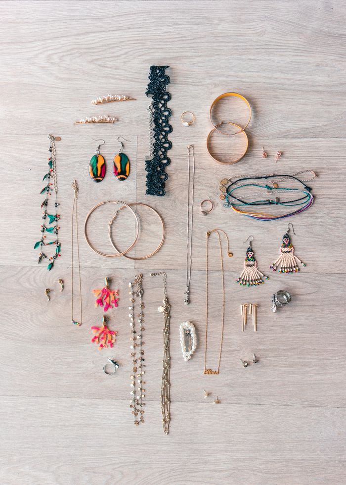 Various elegant jewelry pieces beautifully arranged in a flat lay style on a light wooden surface, ideal for fashion design.